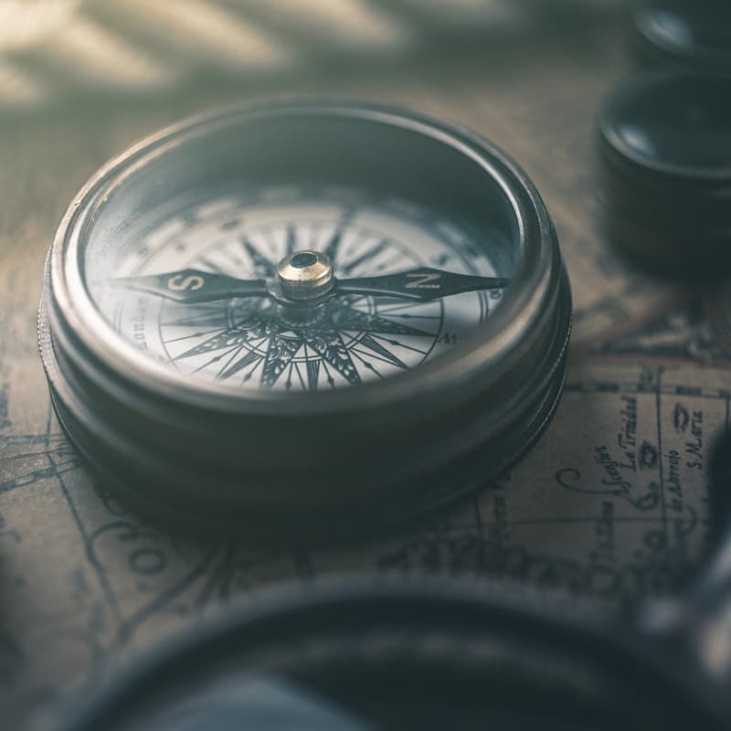 Old fashioned compass resting on a map